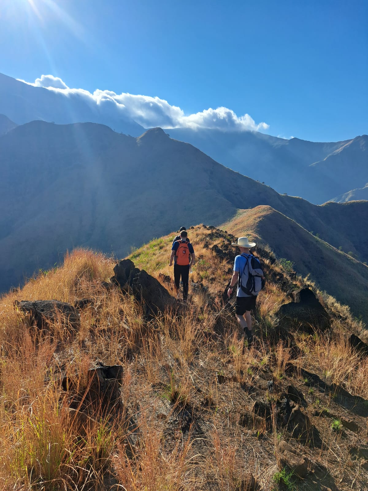 3 men hiking on a ridge of a moutain